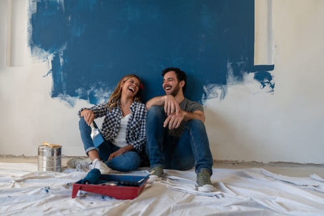 Couple taking a break from painting a wall