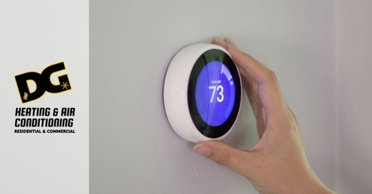 Hand adjusting smart thermostat.
